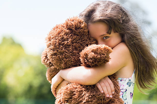 Girl embracing teddy bear Cute little girl embracing her new teddy bear and looking at camera. Portrait of lovely female child with her peluche outdoor. Little girl playing with her doll. shy photos stock pictures, royalty-free photos & images