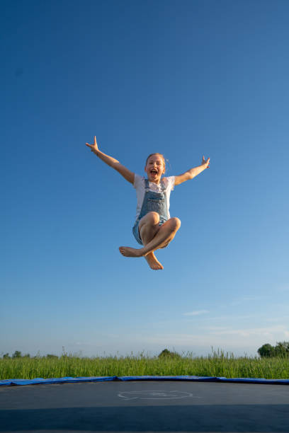 Girl enjoying jumping on trampoline stock photo