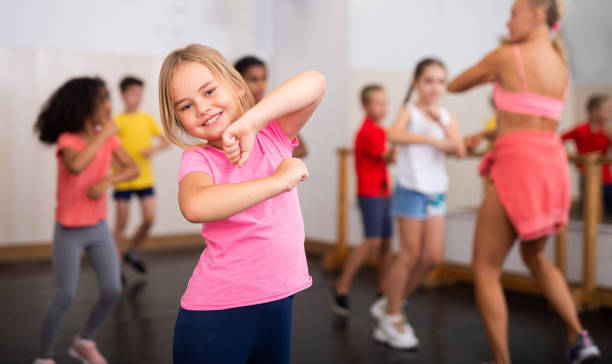 Girl exercising in group during dance class stock photo