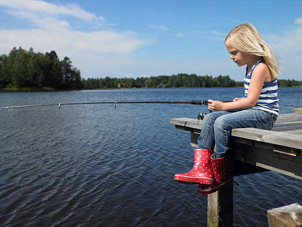Girl fishing from a dock Ryd, Sweden swedish girl stock pictures, royalty-free photos & images