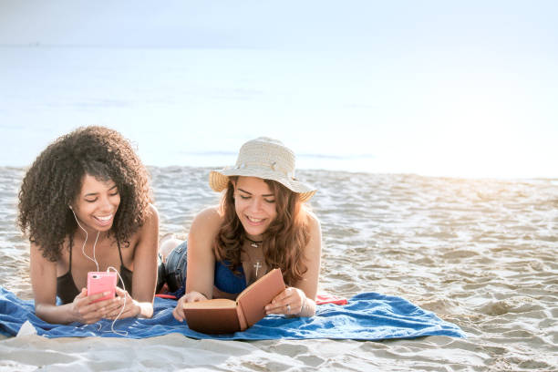 2 girl friends lying on beach vacation. stock photo