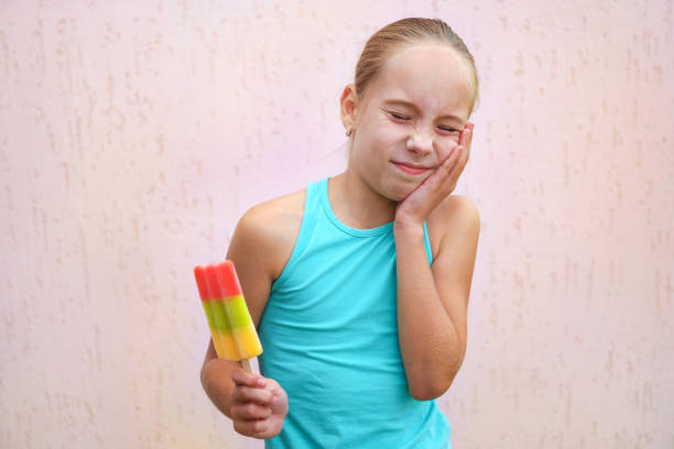 Girl has toothache from cold ice cream.  rotten teeth in children stock pictures, royalty-free photos & images