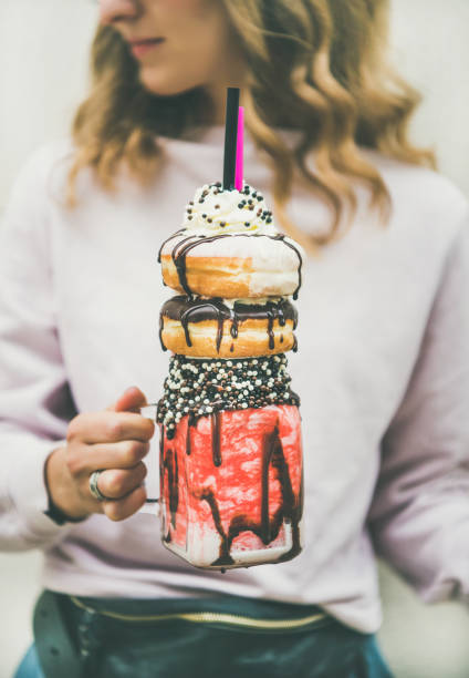 meisje houden koude aardbei donut freakshake in mason jar - freakshake fruit stockfoto's en -beelden