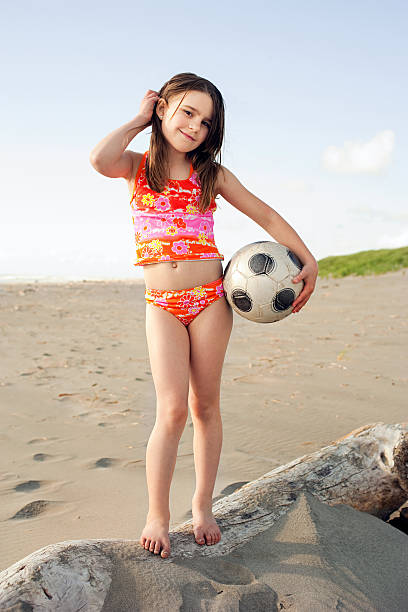 Girl holding soccer ball at beach Portland,Oregon,USA, little girls in bathing suits stock pictures, royalty-free photos & images