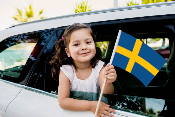 Girl Holding Swedish Flag Girl holding Swedish Flag in the car. swedish girl stock pictures, royalty-free photos & images