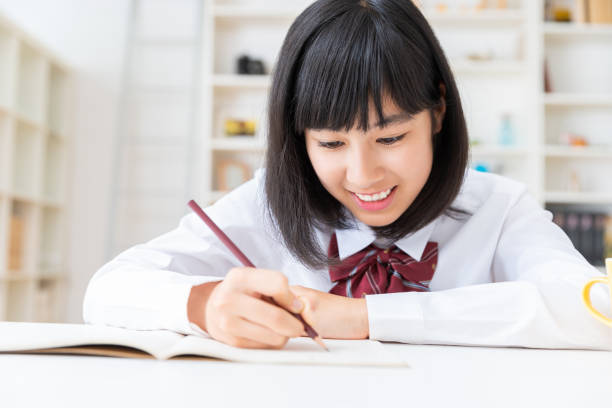 勉強する制服を着た少女 - 中学生 ストックフォトと画像