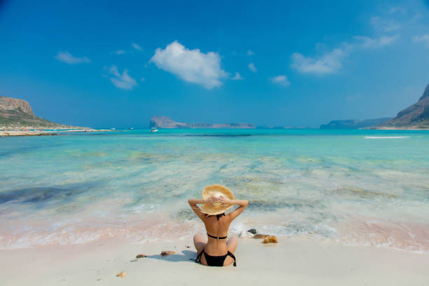 girl in black bikini and with hat on Balos beach stock photo