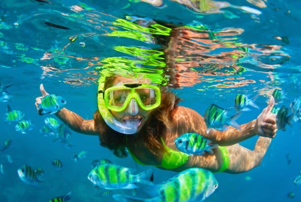 Girl in snorkeling mask dive underwater with coral reef fishes Happy family - girl in snorkeling mask dive with tropical fishes in coral reef sea pool. Travel lifestyle, water sports outdoor adventure, underwater swimming on summer beach holiday with kids. woman snorkeling stock pictures, royalty-free photos & images