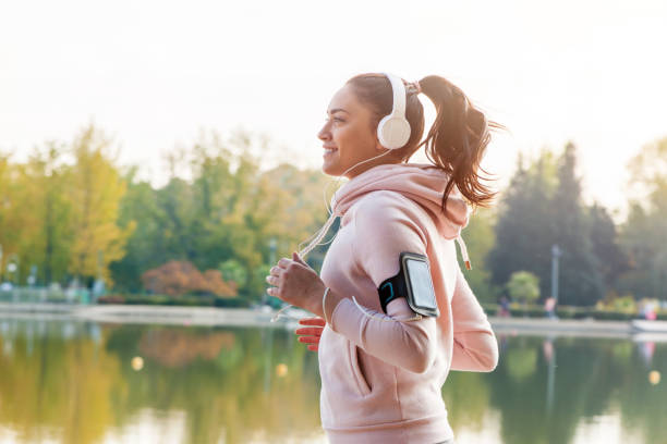 Girl is runing on the city  and listening the music stock photo
