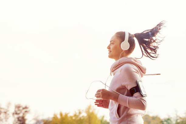Girl is runing on the city  and listening the music stock photo
