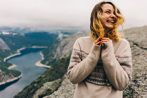 Girl laughing on the Trolltunga Girl standing on the Trolltunga and laughing  norway stock pictures, royalty-free photos & images