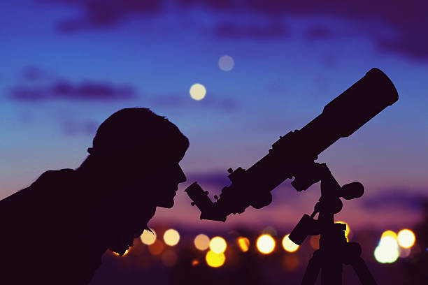 Girl looking at the stars with telescope beside her. Girl looking at the stars with telescope beside her and de-focused city lights. My astronomy work. astronomy telescope stock pictures, royalty-free photos & images