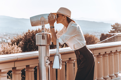 Girl looks at the panorama of Florence through a binoscope. The concept of tourism, travel.
