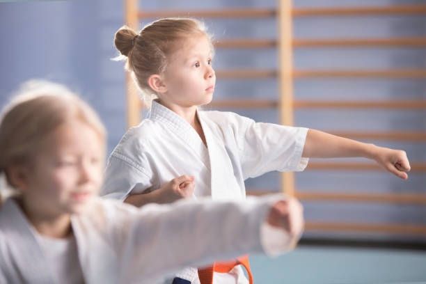 Girl on karate class Young girl in kimono exercising on karate class karate stock pictures, royalty-free photos & images
