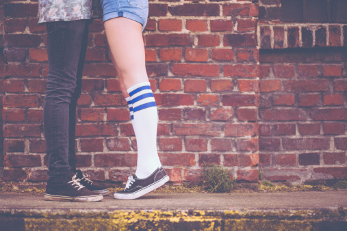 Girl On Tip Toes Hugging Boyfriend Stock Photo - Download Image Now