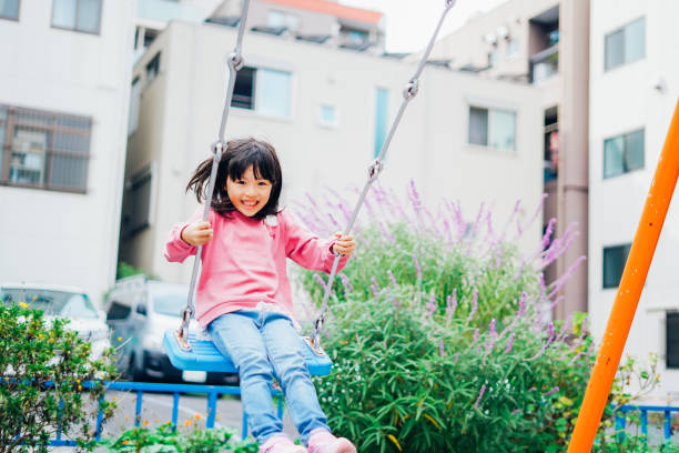 Girl playing with swing at a park Girl playing with swing at a park child korea little girls korean ethnicity stock pictures, royalty-free photos & images