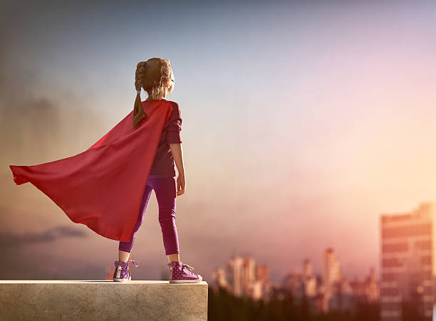 girl plays superhero Little child girl plays superhero. Child on the background of sunset sky. Girl power concept costume photos stock pictures, royalty-free photos & images