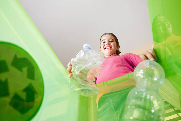 Girl recycling plastic bottles stock photo