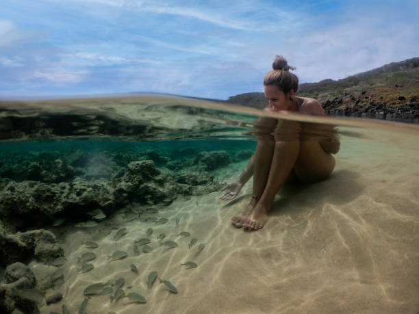 ragazza che si rilassa sull'acqua con i pesci. acqua limpida a lion beach, fernando de noronha - leao foto e immagini stock