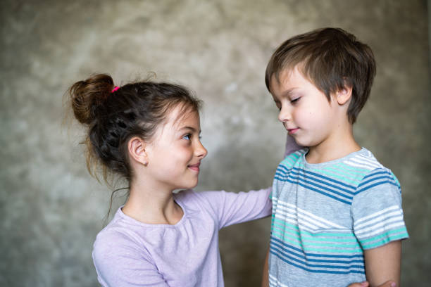 Girl show love and care for her little brother stock photo