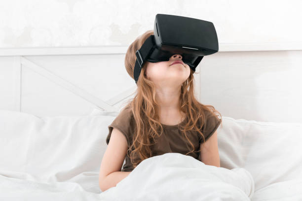 flickan sitter i sängen med vr-glasögon på ser upp - virtual reality headset bildbanksfoton och bilder