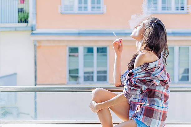 Girl smoking on the balcony stock photo