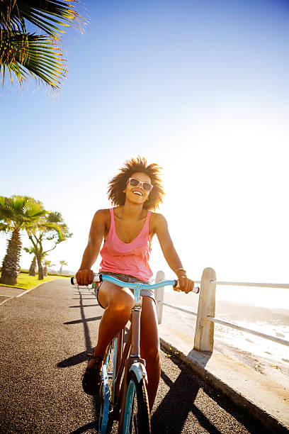 girl taking a seaside ride with bike - fietsen strand stockfoto's en -beelden