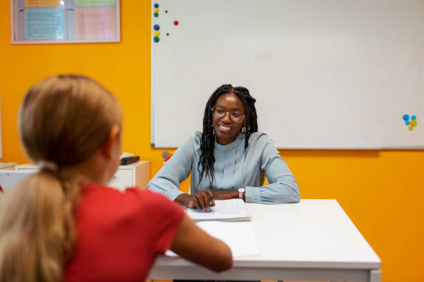 Girl Talks With Teacher In The Classroom stock photo