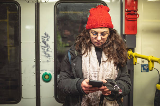 meisje van het tekstoverseinen terwijl het nemen van een metro-trein - subway snapshot stockfoto's en -beelden