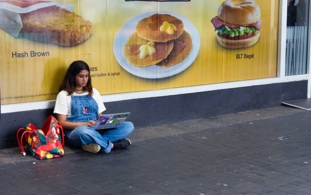 photos/girl-using-a-laptop-sitting-on-the-street-picture-id672229538?