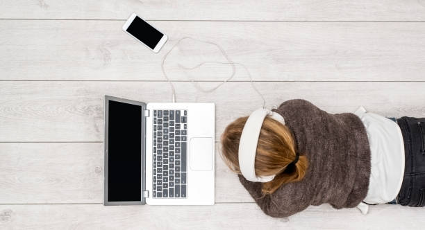 girl using laptop and smartphone header stock photo