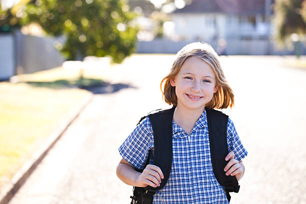 Girl walking home from school stock photo