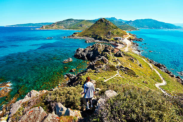 Girl walks down from Genoese Tower of Parata peninsula Corsica, France - April 15, oung Girl walk down from Genoese Tower of Parata peninsula, grandiose panorama of West Corsican litoral is at background. Ajaccio, Corse-du-Sud, the west coast of the French island of Corsica corsica stock pictures, royalty-free photos & images