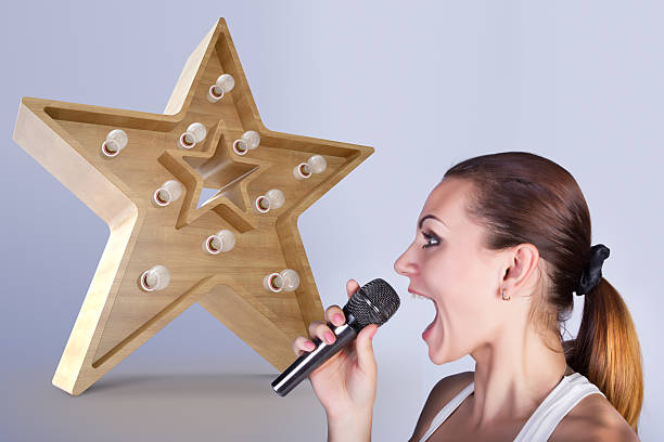 Girl with a microphone on the background of sign star.