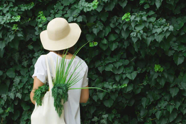mädchen mit einer öko-tasche auf einem saftigen grünen hintergrund. - sustainability fashion stock-fotos und bilder