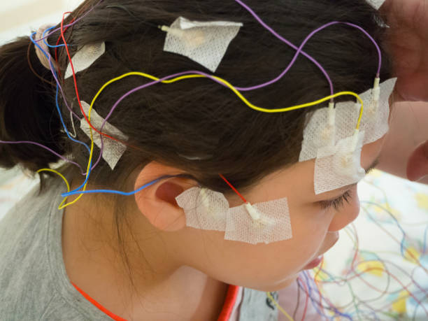 Girl with EEG electrodes attached to her head for medical test Girl with EEG electrodes attached to her head electrode stock pictures, royalty-free photos & images