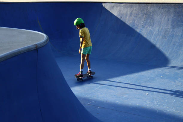 Girl with green helmet at the skate park stock photo