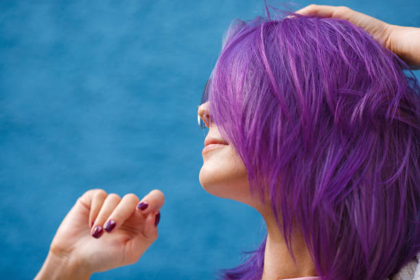 girl with purple hair on blue background stock photo