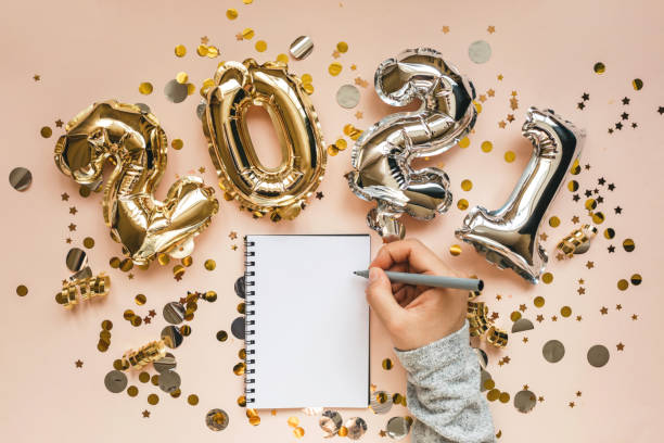 Girl writes goals for 2021 A girl writes goals for the 2021 New Year or a wish list or a letter to Santa in a notebook. new years eve girl stock pictures, royalty-free photos & images