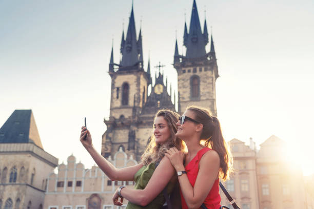 Girlfriends taking selfies in front of Tyn Church in Prague Girlfriends taking selfies in front of Tyn Church in Prague prague old town square stock pictures, royalty-free photos & images