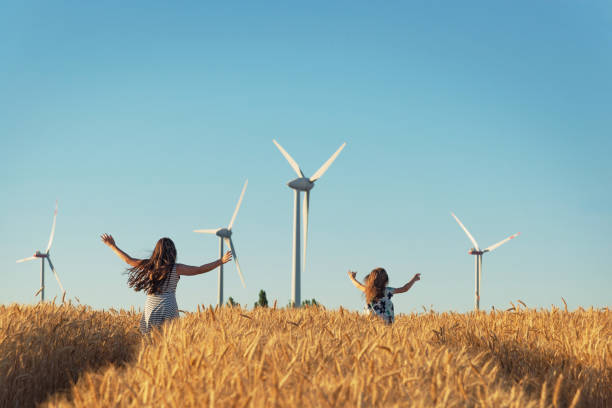 Girls are running the way to wind energy stock photo