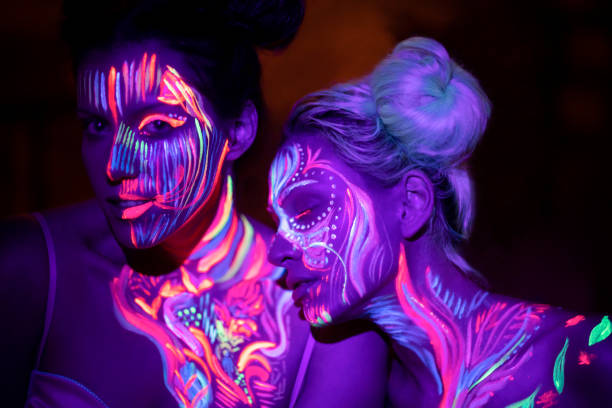 Girls From Another Planet Two beautiful girls with fluorescent body paint. paint neon color neon light ultraviolet light stock pictures, royalty-free photos & images