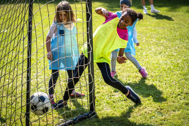 Girls playing match on soccer field stock photo