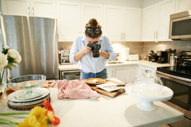 Giving her followers a taste of her specialty Shot of a young woman using a camera to take a picture of the pie she’s baked at home food photos stock pictures, royalty-free photos & images