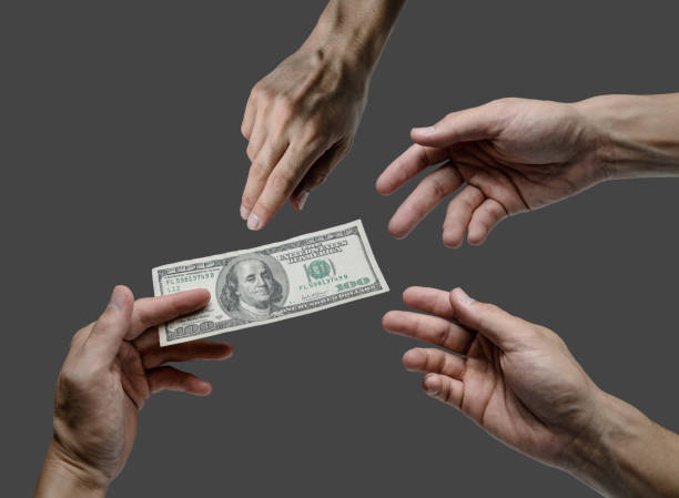 giving one hundred dollar bill to many hands isolated background stock photo