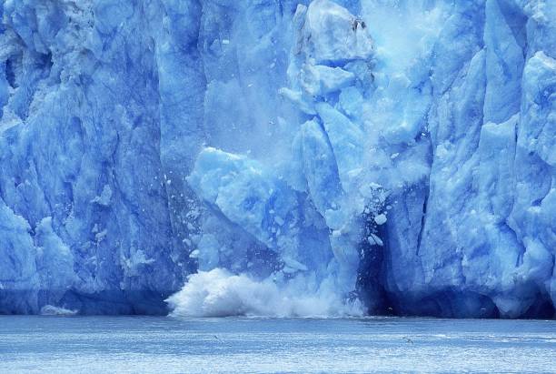 glacier in alaska, piece of ice falling into ocean, symbol for the lobal warming - climate change imagens e fotografias de stock