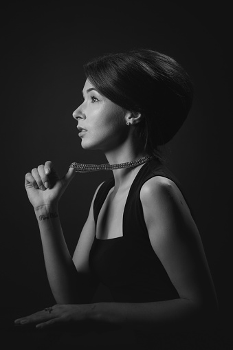 Black and White profile portrait of a beautiful woman with a necklace.