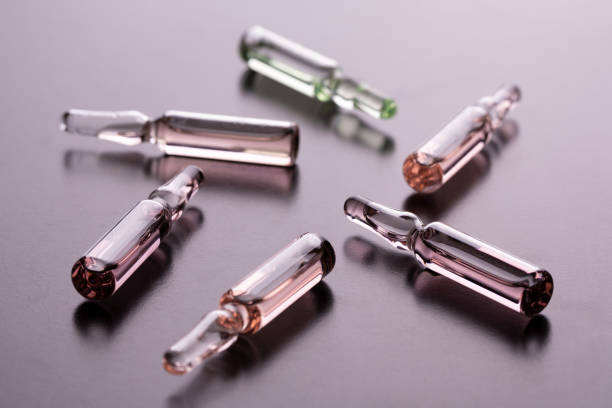 Glass ampoules on the table. Scattered ampoules with medicine. Lots of glass ampoules on the table. ampoule stock pictures, royalty-free photos & images