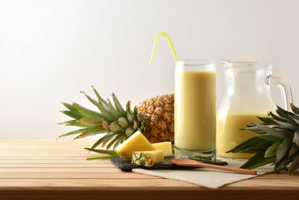 Glass and jug with pineapple juice isolated background. stock photo