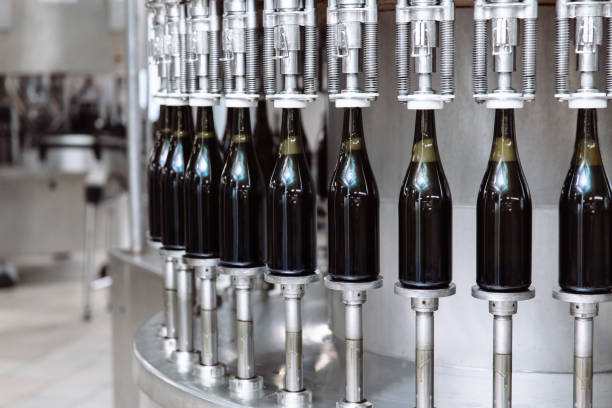 Glass bottles on the automatic conveyor line at the champagne or wine factory. Plant for bottling alcoholic beverages stock photo